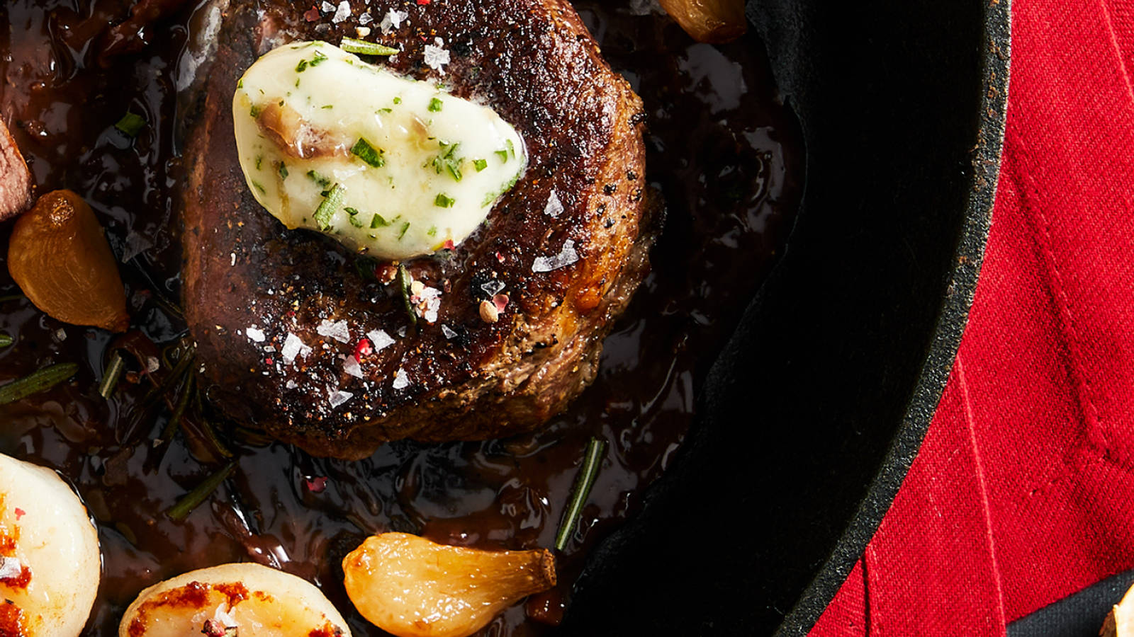 Good Chop premium steak topped with herb butter in a cast iron pan